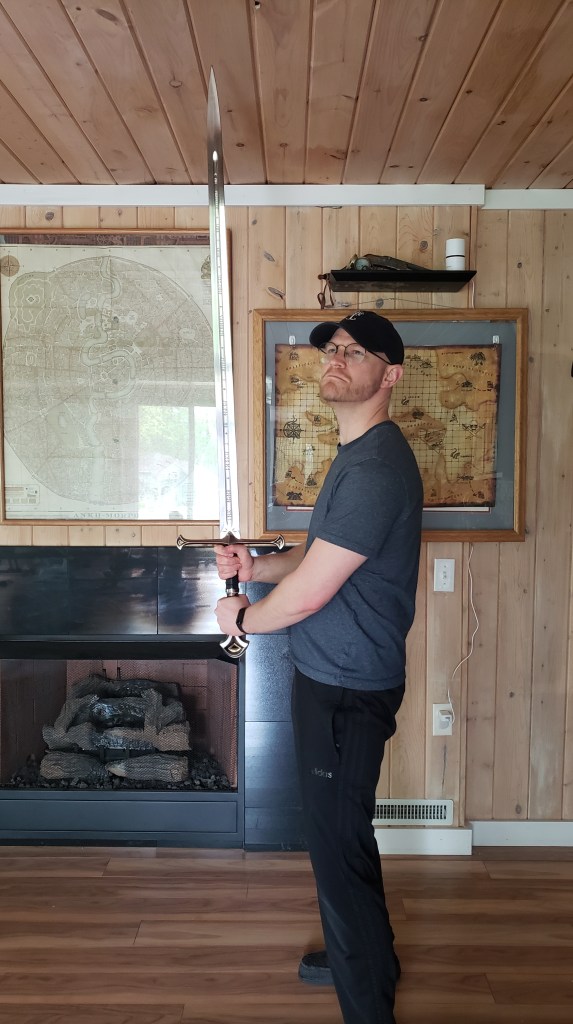 A fantasy author holding Anduril, The Flame of the West, Aragorn's sword from The Lord of the Rings by J.R.R. Tolkien